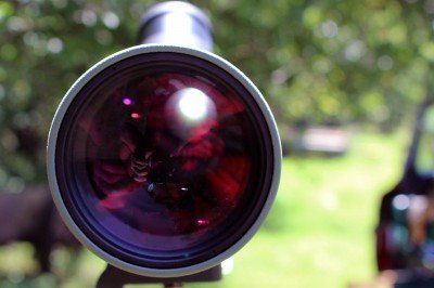 The front lens is large, and coated for maximal transmission of light. It also has a sun shield that slides out over it to prevent too much light transmission.