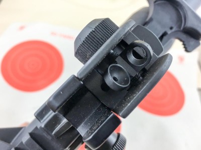 The rear sight includes both large and small apertures for speed and precision respectively.