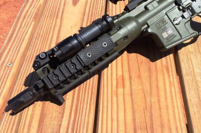 The short 8.5" barrel features an open-pronged muzzle device and is surrounded by a compact handguard.