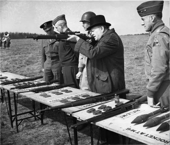 Prime Minister Winston Churchill was always interested in small arms. He is shown here with General Eisenhower inspecting and shooting a selection of infantry weapons, including the new Model 1903A4. Note the ammunition clips on the table. U.S. Army Signal Corps photo.