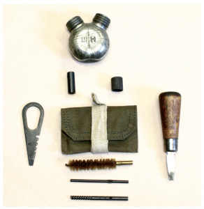 A typical cleaning kit for Mosin-Nagants, including canvas pouch with tape closer, stamped-steel combination tool, oil/alkali solution bottle, rod collar, brush, jag, muzzle guide and tommy bar. (Author’s Collection) 