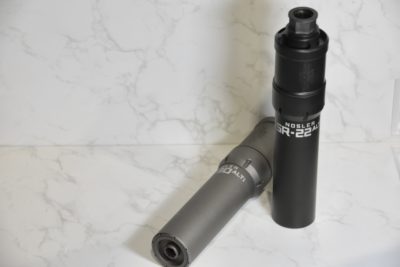 Two suppressors on a white backdrop.