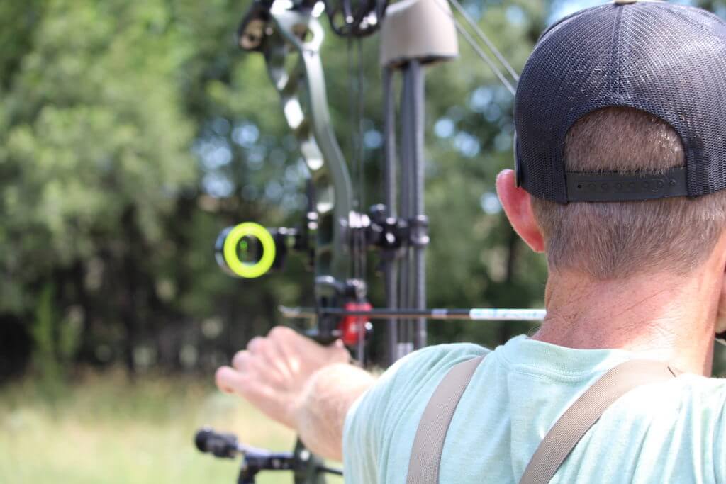Bowhunter aiming with sights on bow