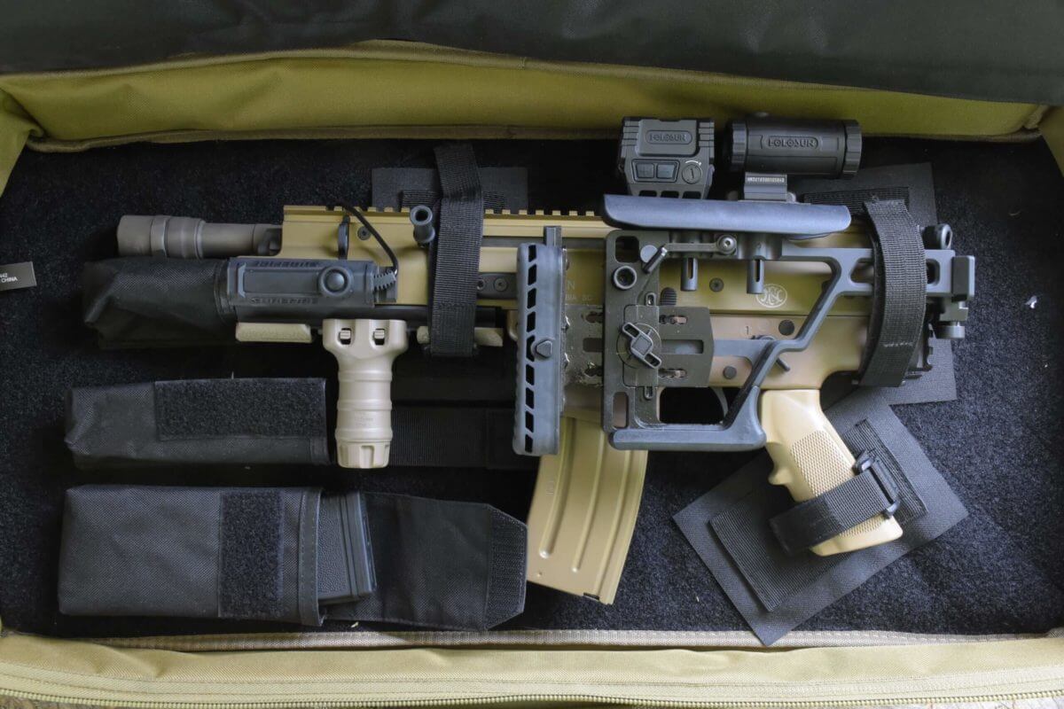 The scar 15P sits in a carry case and is fitted with Holosun optics, a TangoDown grip, and Surefire light.