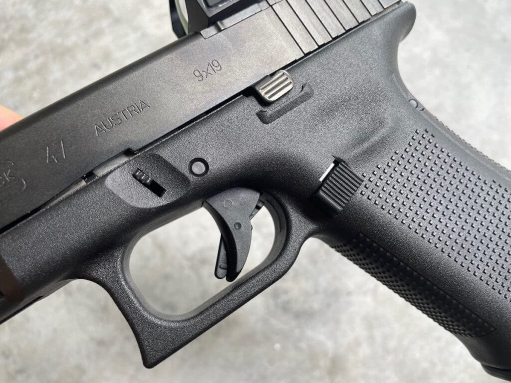 Enlarged magazine release button on Glock Gen5 pistol.