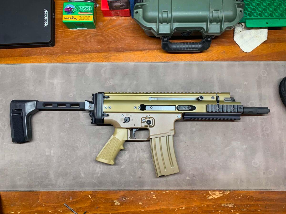 Scar 15P with a pistol brace on a work bench.