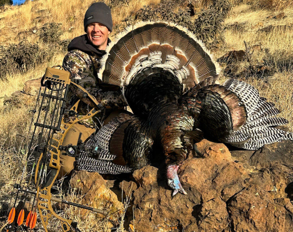 Hunter with bow, SEVR broadheads, and turkey