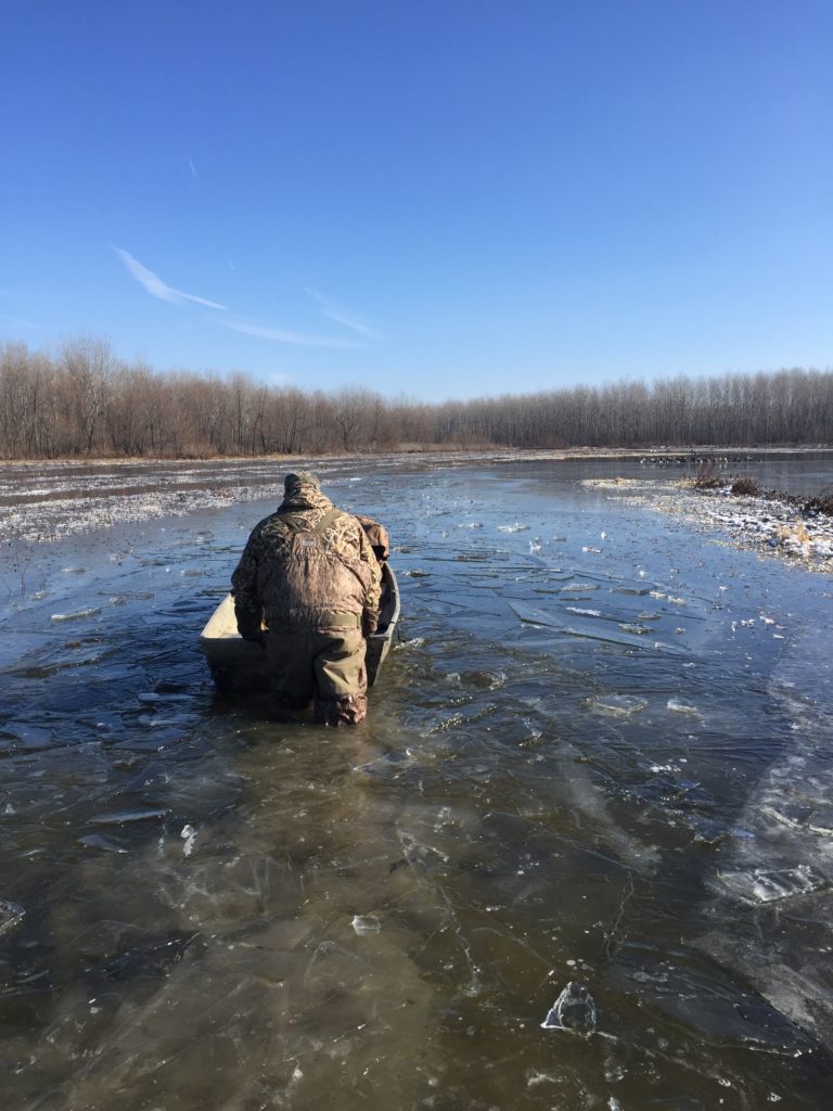 Hunter pushing gear through icy water