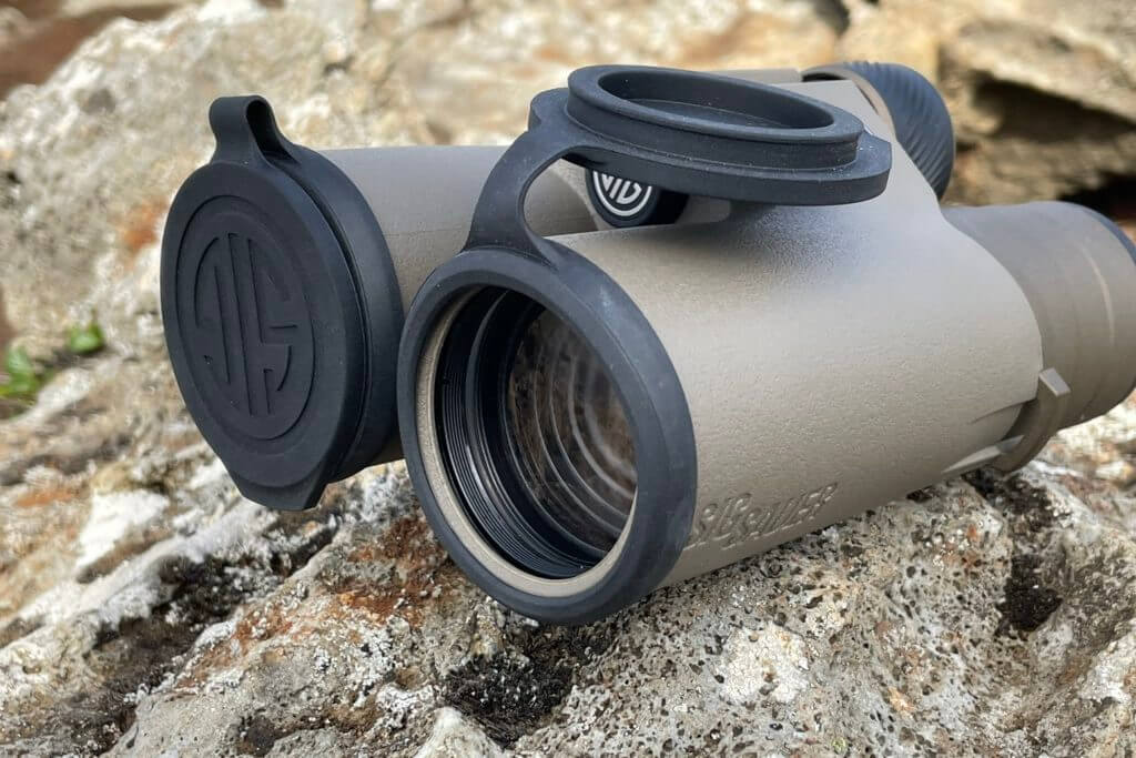 SIG Binoculars with lens covers on colorful lava rock