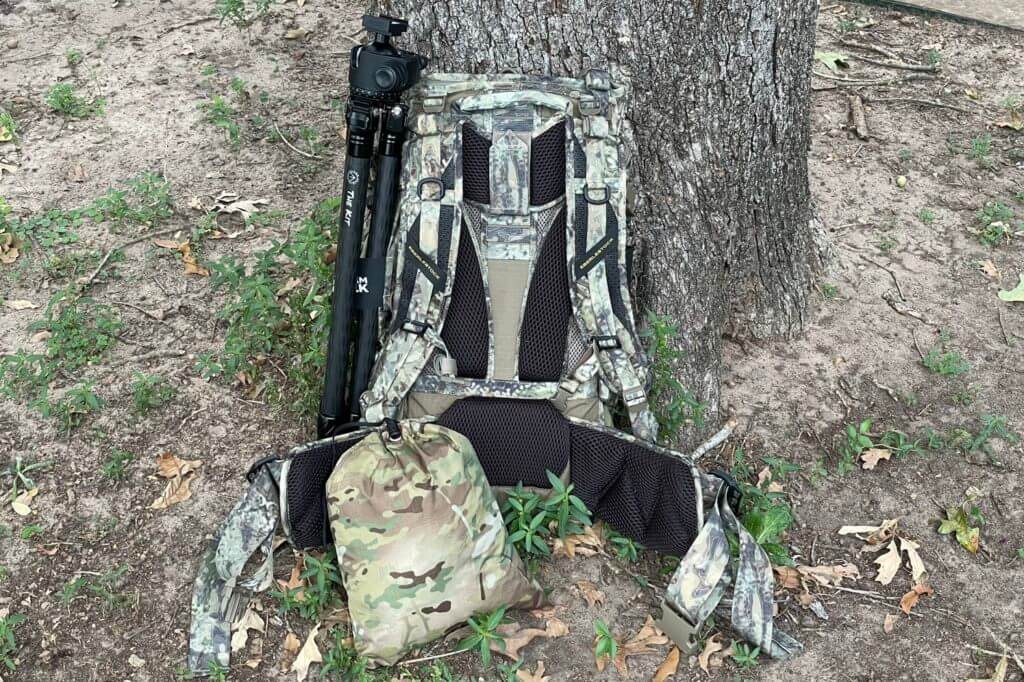 Two Vets Tripods "The Kit" on the side of the Eberlestock Team Elk V2 pack with the tent in the included stuff sack on the ground in front