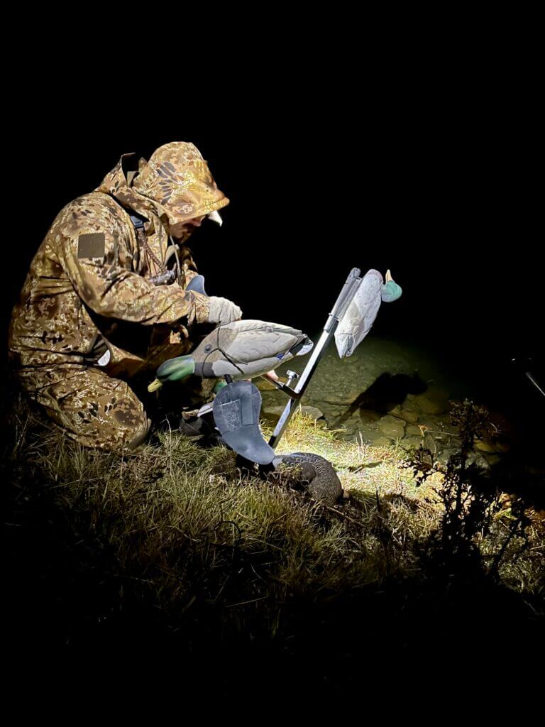 Dress for Success. Hunter setting up duck decoy in warm Kryptek gear