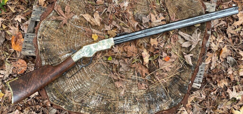 New Original Henry rifle resting on a rustic tree stump