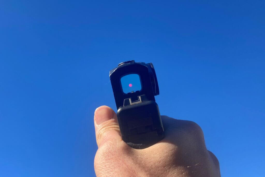 Looking through a red dot optic at a bright blue sky