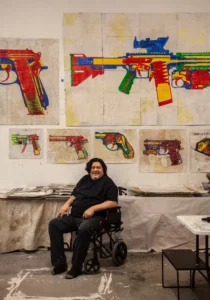 Alfredo Martinez in front of his gun art.