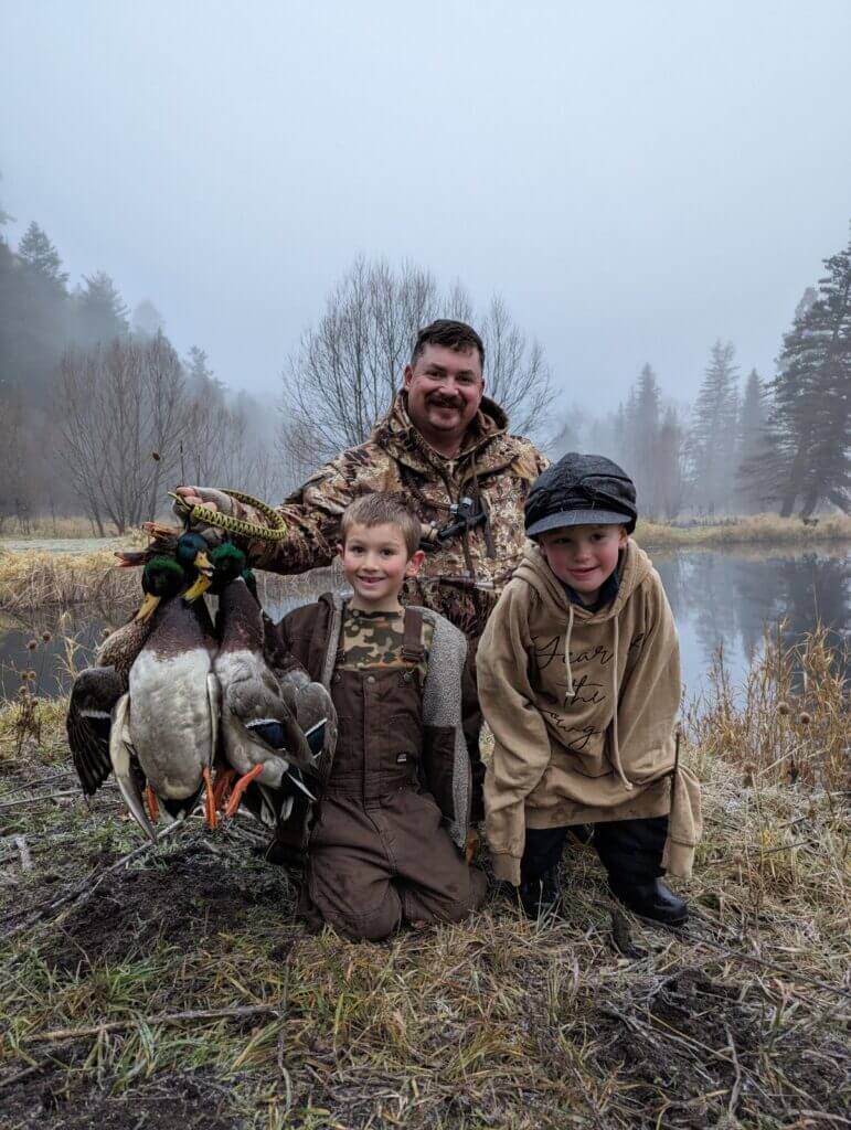 Hunter with two kids and a handful of ducks