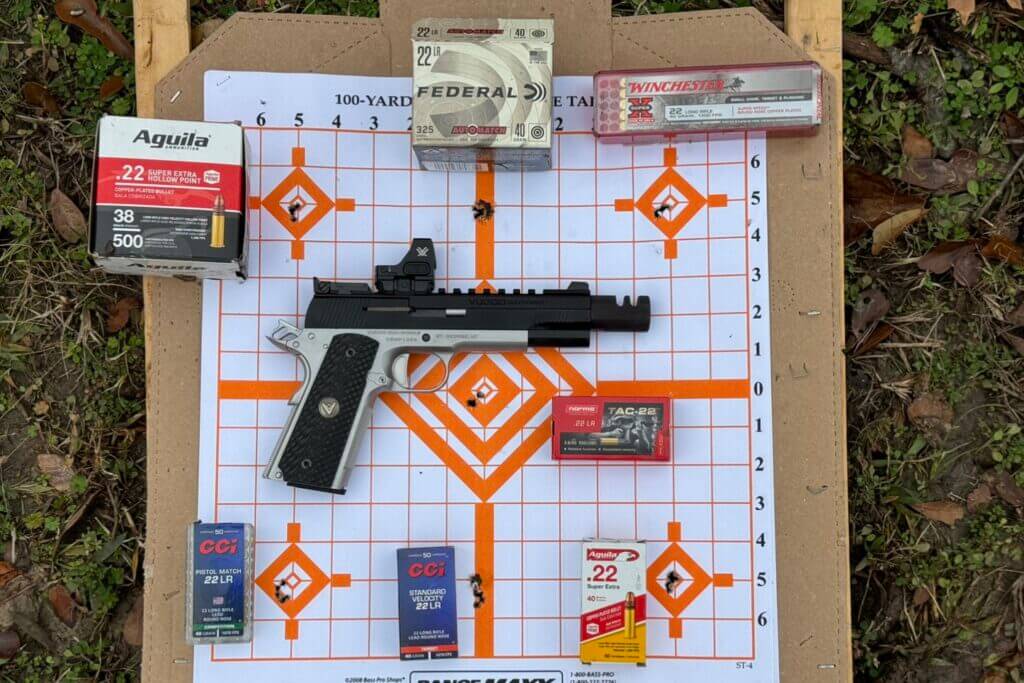 Each box of ammunition placed next to the 5-round group I got shooting from 10 yards. Top and bottom middle groups have a piece of mud I used as a reference point, those are not holes.