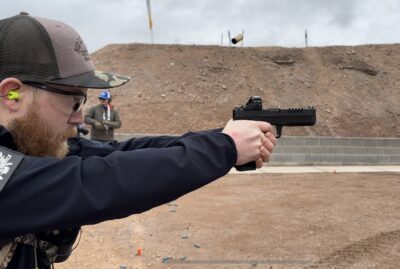 A man shoots the RIA 5.0E handgun at the range during SHOT Show 2024.