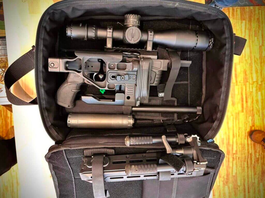 A rifle is taken apart and lies in a laptop case.