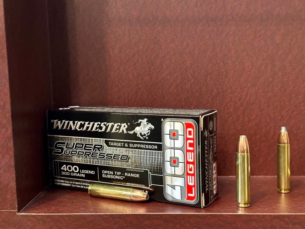 A box of ammunition is displayed on a shelf that also has loose cartridges sitting on it.