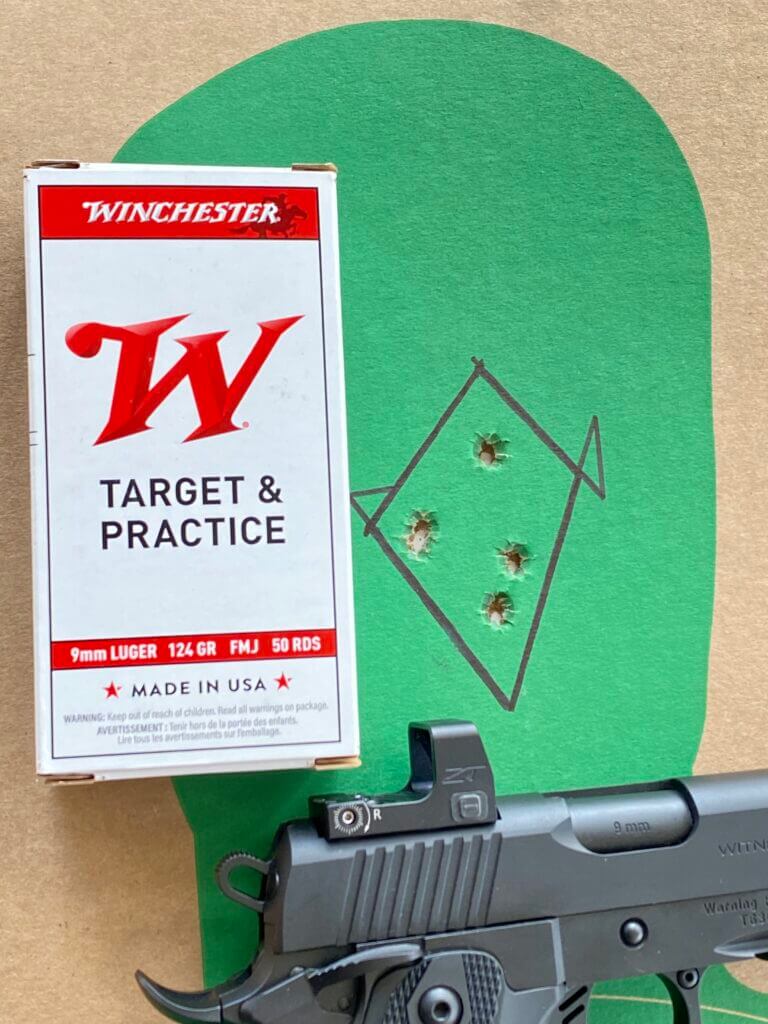 Handgun with red dot next to ammo box and target