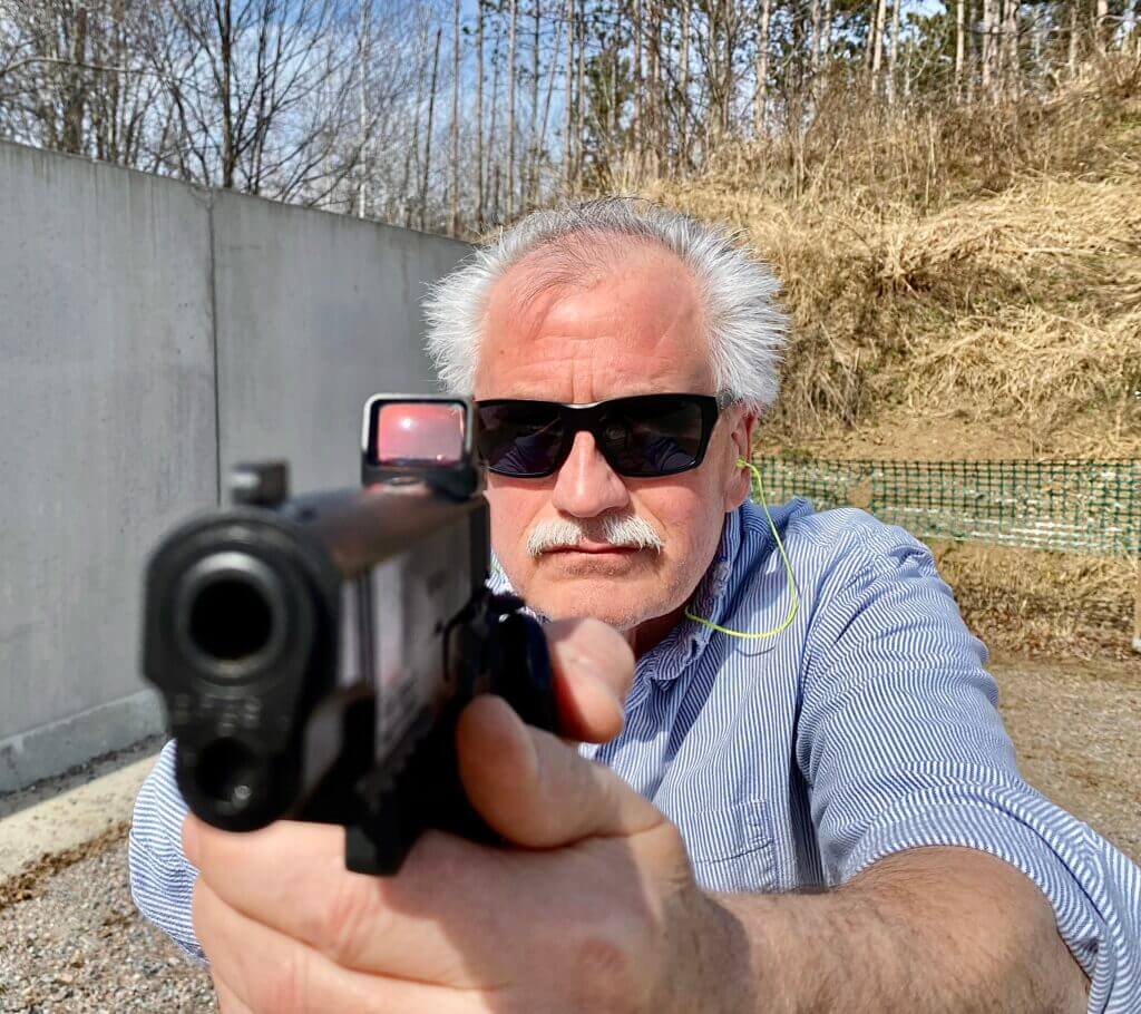 Man aiming a Girsan handgun with the ZeroTech Thrive HD red dot