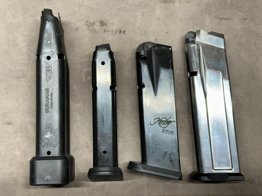 Four Kimber KDS9C magazines are laid side-by-side to compare their similarities.