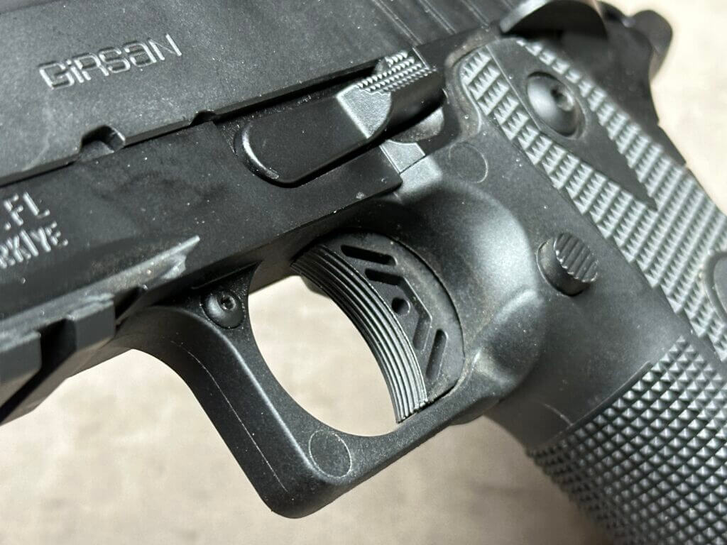 A closeup of the trigger and magazine release of the 1911-style Girsan Witness2311 pistol.