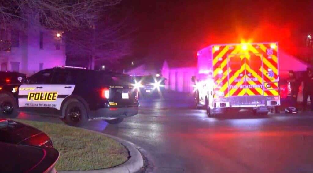 Police vehicles and ambulance on scene of shooting at an apartment complex