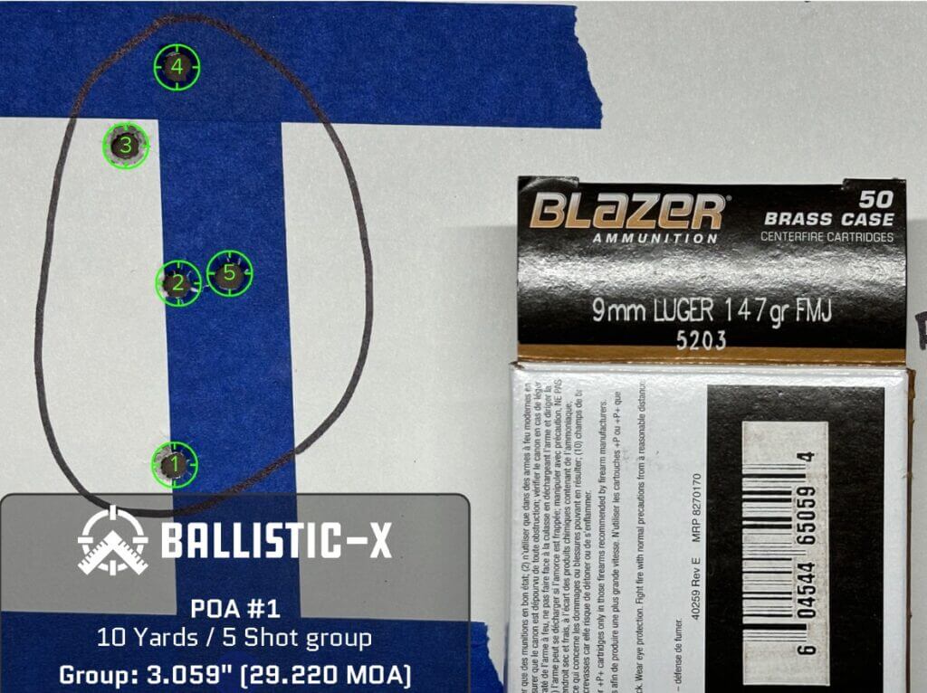 A paper target displays a 5 round group of shots.