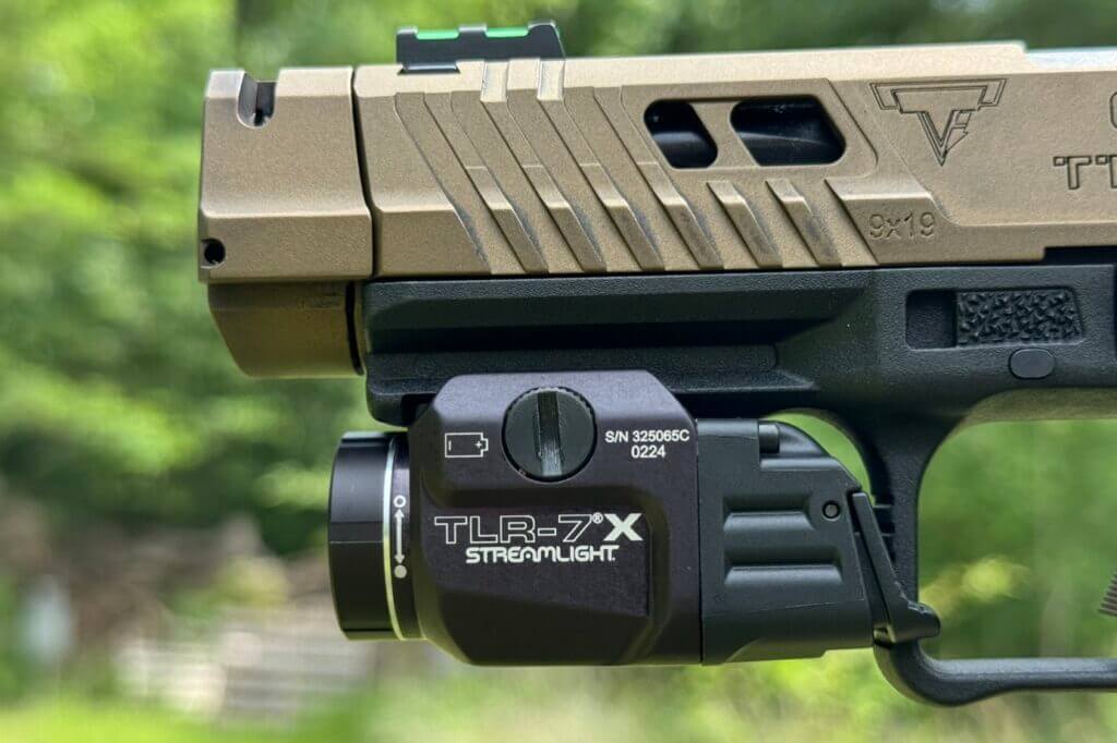 A Streamlight light mounted to a tan pistol