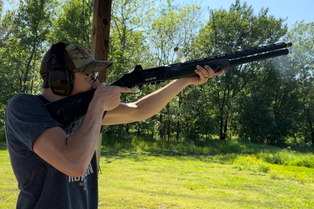 A shooter aiming his shotgun with the Holosun SCS Carry installed to the top