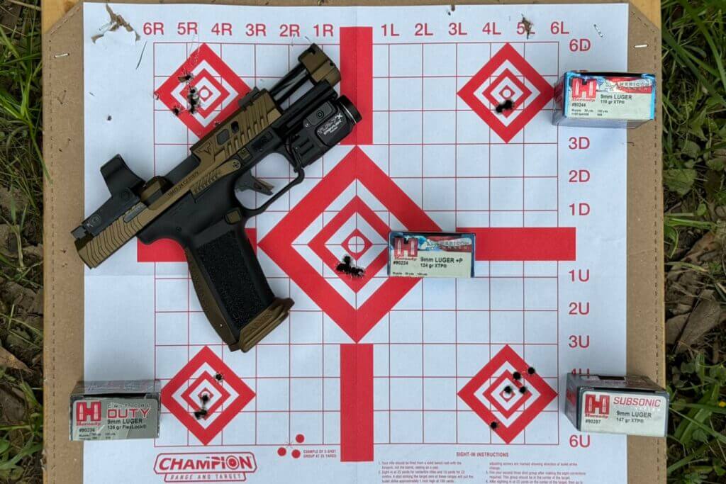 The CANiK TTI Combat pistol with a red dot and a weapon-mounted light installed laying on a target surrounded by ammo boxes