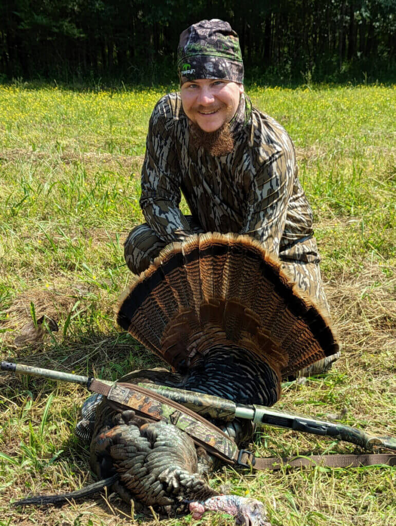 Hunter with turkey and a Mossberg 500 Turkey shotgun