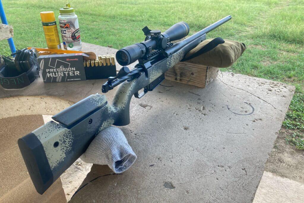 Camo rifle with scope resting on blocks