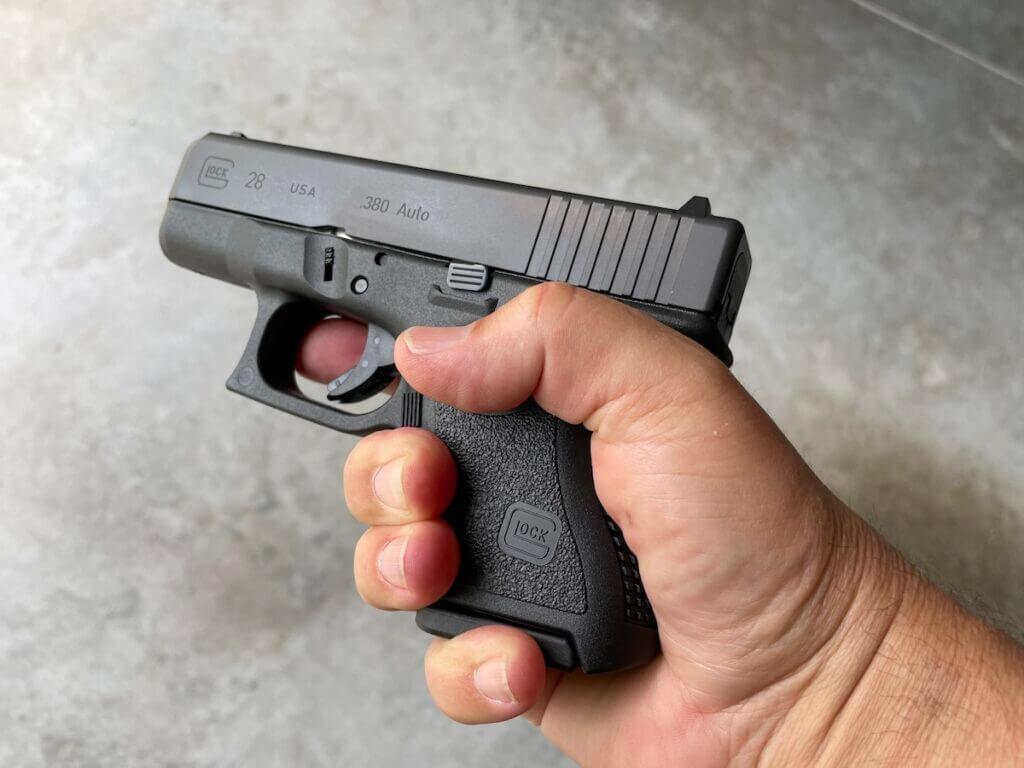 Man holding small Glock 28 pistol