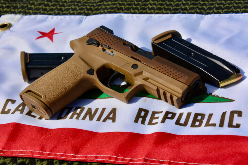 Sig Sauer M18 P320 with magazines on a California flag