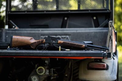 A lever action S&W rifle on the bed of a truck.