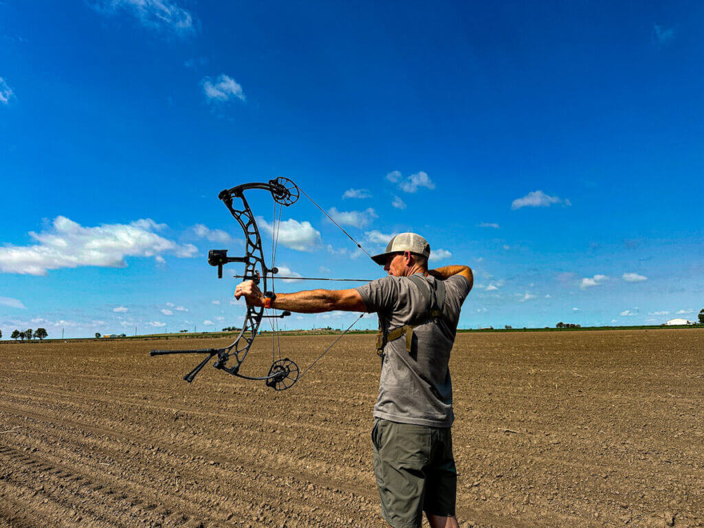 Man with large hunting bow in field