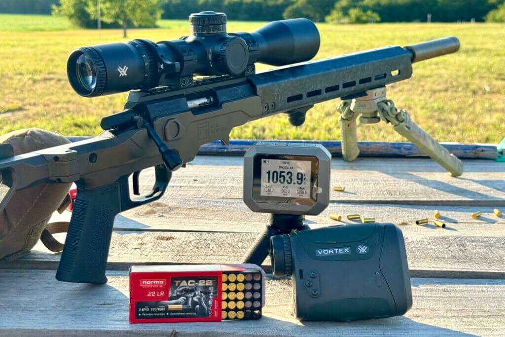 Christensen Arms rifle on wooden table with range finder and chronograph