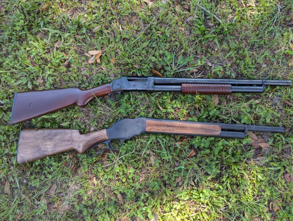 Two blued steel and wood shotguns on the grass