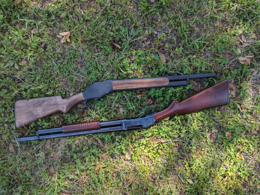 Two Winchester shotguns on grass