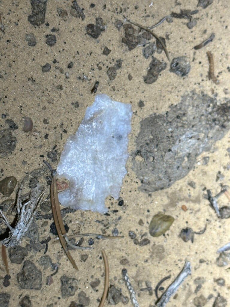 A stone point lying on the sand.