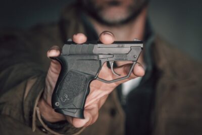 A man holding up a TUC22 pistol.