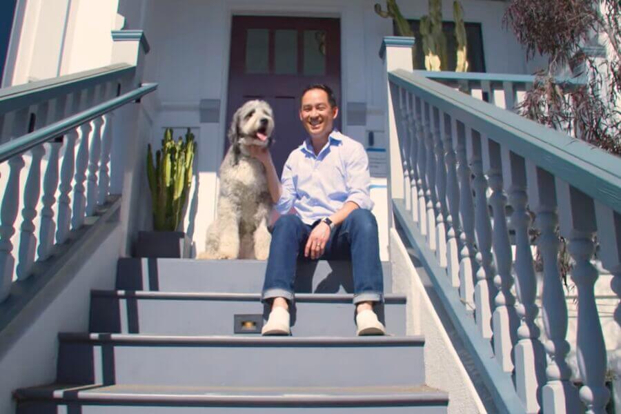 A man sitting on the stoop with his dog.