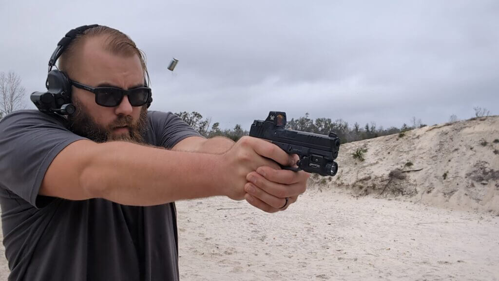 Man with glasses and hearing protection shooting  semi-automatic handgun