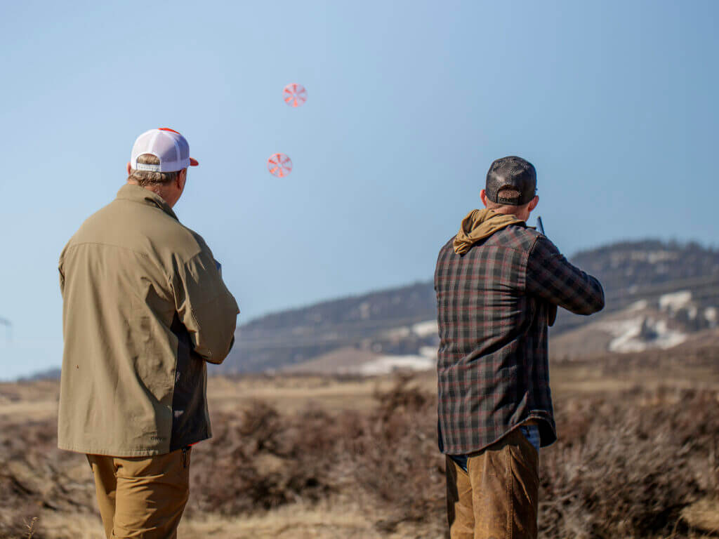 two men shooting at clay pigeons