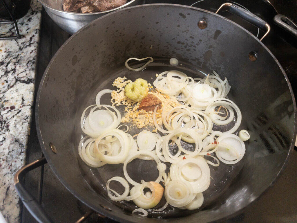 Onions and aromatics sauteing in a pot.