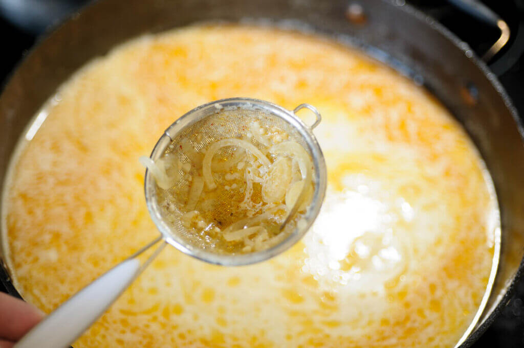onions in a strainer over the soup pot.