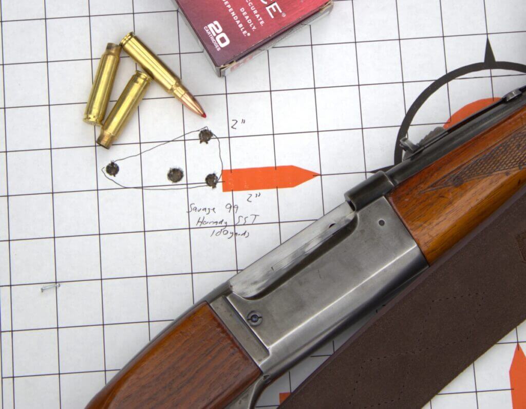 rifle on paper target next to a few rounds of ammo