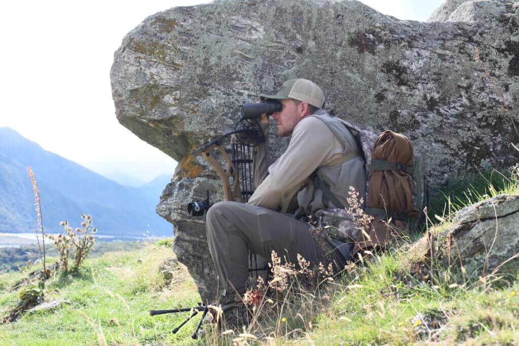 Man sitting by rock Bowhunting Tahr